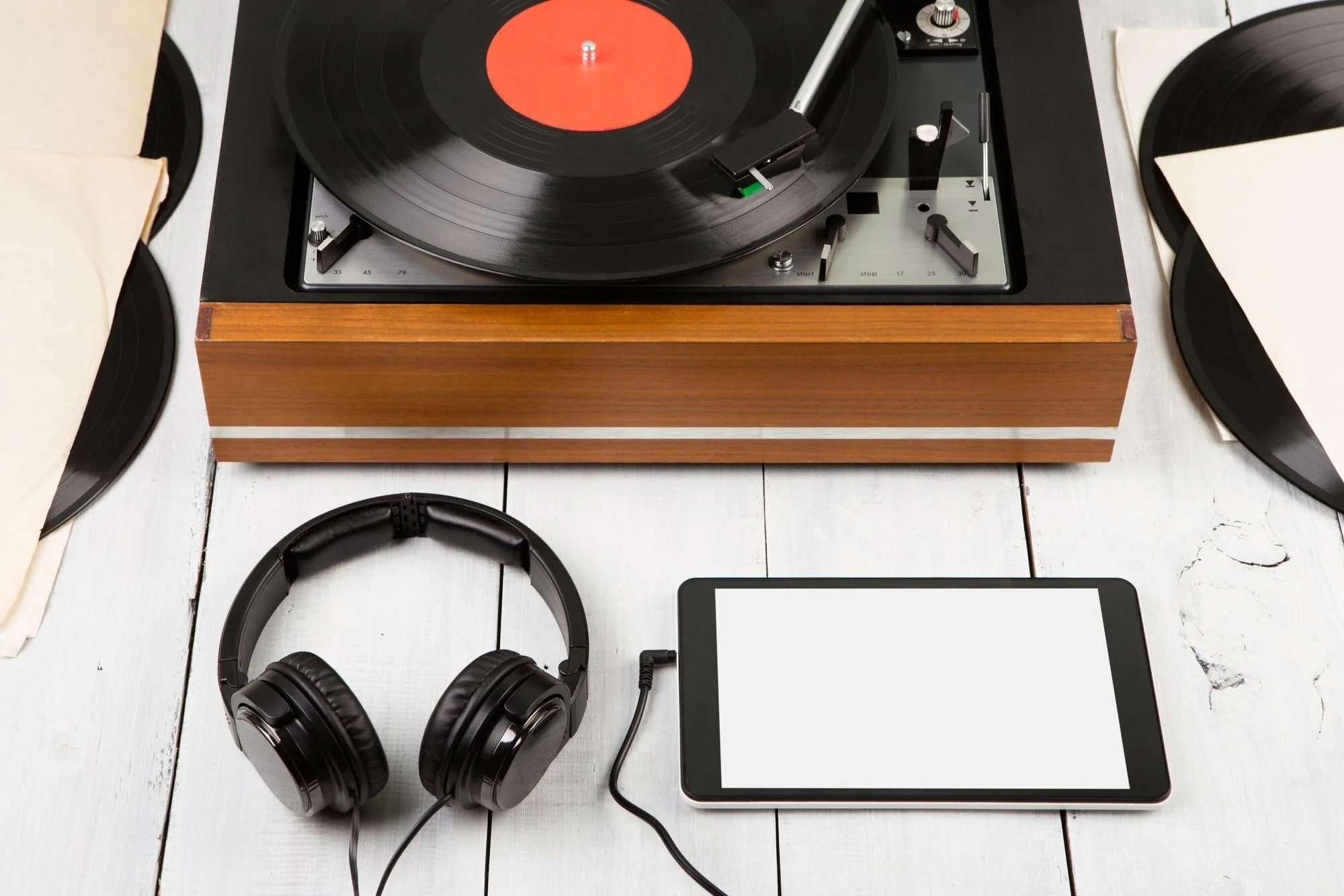 Skivspelare, smartphone och hörlurar som illustrerar vinyl jämfört med streaming